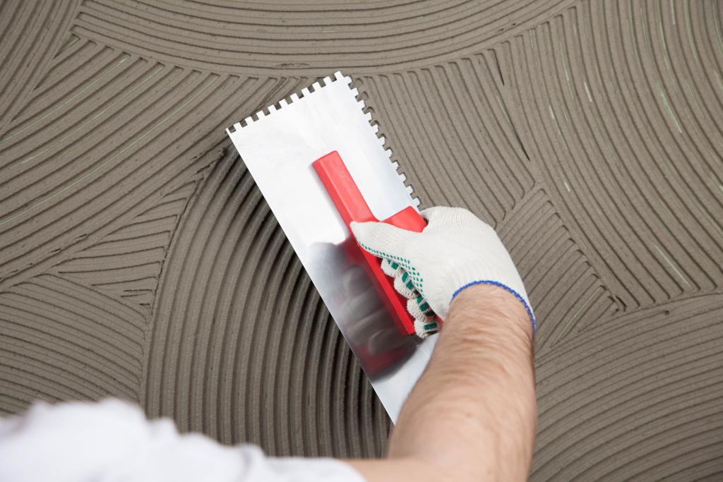 Man using tool to tile